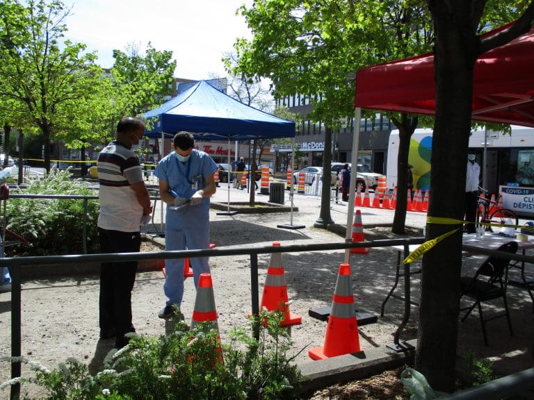 Staff of CIUSSS West Central takes down a resident's contact information outside the mobile COVID-19 testing clinic, set up beside Parc metro station in Montreal's Park Extension borough. Photo: Avleen K Mokha