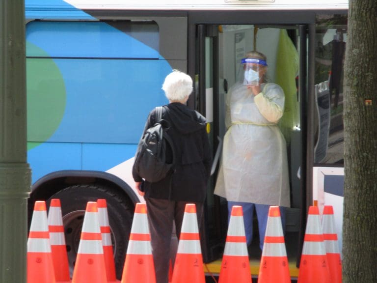 Staff of CIUSSS West Central speak with a resident outside the mobile COVID-19 testing clinic, set up beside Parc metro station in Montreal's Park Extension borough. Photo: Avleen K Mokha